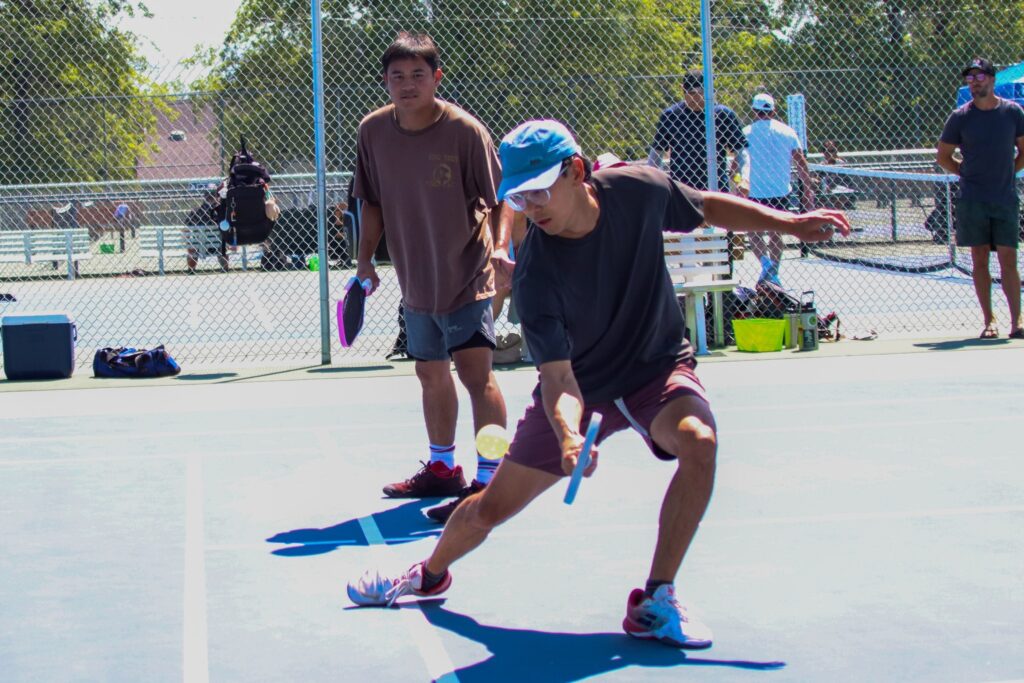 Adult pickleball players rallying during a drill at the Reno Tennis Center
